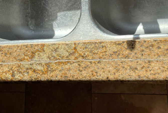 This BEFORE image shows the crack in the granite in front of the sink.