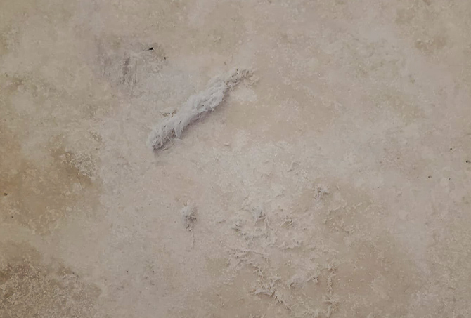 The travertine had a coating. We scraped a bit of it away for demonstration purposes.