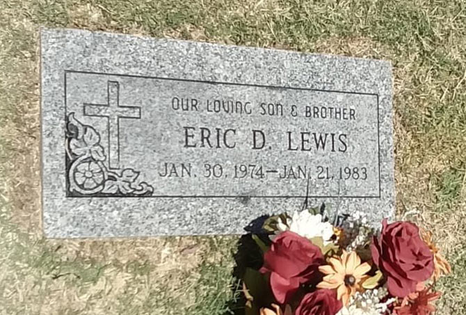 A granite headstone has stains.