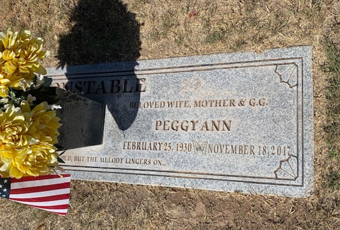 A granite headstone has stains.