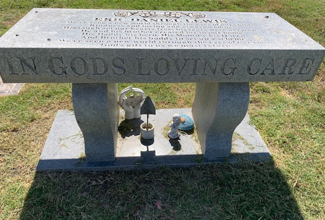 A granite memorial bench has stains.