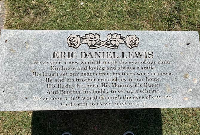 A granite memorial bench has stains.