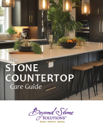 Kitchen island with a stone countertop and pendant lights; overlay text reads 'The Stone Countertop Care Guide' and 'Beyond Stone Solutions' logo.